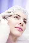 Técnico de beleza injetando botox no rosto feminino . — Fotografia de Stock