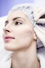 Dermatologo disegno segni sulla faccia della donna per thread-lift, primo piano
. — Foto stock