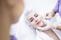 Dermatologist drawing marks on woman face for thread-lift, close-up. — Stock Photo