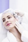 Dermatologe appliziert Fadenapplikator auf weibliches Gesicht, Nahaufnahme. — Stockfoto