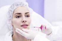 Dermatologo che inietta botox sulle labbra femminili, primo piano
. — Foto stock