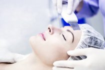 Young woman receiving facial microdermabrasion treatment in clinic, close-up. — Stock Photo