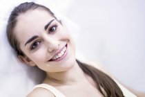 Portrait of smiling young woman sitting on chair in clinic, close-up. — Stock Photo