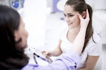 Dermatologista examinando a pele facial do paciente . — Fotografia de Stock