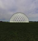 Geodesic dome illuminated from within in field at dusk, digital illustration. — Stock Photo
