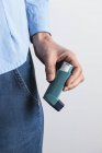 Primo piano dell'inalatore per l'asma a mano maschile . — Foto stock