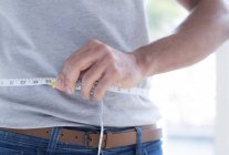 Close-up of healthy man measuring waist. — Stock Photo
