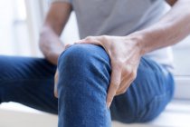Man holding knee in pain, close-up. — Stock Photo