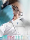 Muestra de pipeteo científico femenino en tubos de microcentrifugación listos para análisis automatizados mientras investigamos biotecnología
. - foto de stock