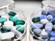 Variedade farmacêutica de cápsulas de medicamentos em placas de Petri
. — Fotografia de Stock