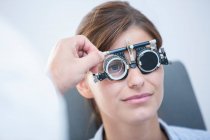 Examen des yeux. Femme portant des montures d'essai lors d'un examen des yeux. — Photo de stock