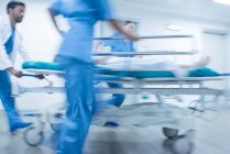 Hospital emergency. Medical staff pushing patient on a gurney. — Stock Photo