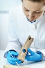 Archaeology researcher in laboratory reconstructing ancient tool. — Stock Photo