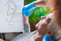 Patient learning about ear points in auriculotherapy treatment. — Stock Photo