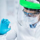 Scientifique tenant un micro tube avec échantillon dans un ancien laboratoire d'analyse de l'ADN . — Photo de stock