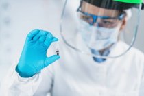 Scientifique tenant un micro tube avec échantillon dans un ancien laboratoire d'ADN . — Photo de stock