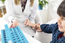 Female immunologist performing skin prick allergy testing on boy for possible allergen. — Stock Photo