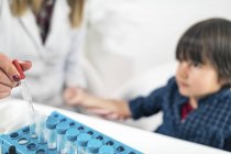 Female doctor performing skin prick allergy testing on boy for possible allergen. — Stock Photo