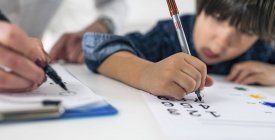Preschooler boy undergoing logic test with numbers for developmental psychology test in female psychologist office. — Stock Photo
