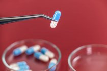 Close-up de duas cores medicina cápsula em pinças, pesquisa farmacêutica
. — Fotografia de Stock