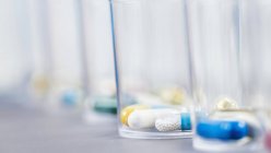 Variedad de píldoras farmacológicas en vasos de plástico desechables, concepto de medicación . - foto de stock