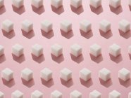 Patrón de terrones de azúcar sobre fondo rosa . - foto de stock