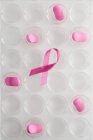 Cinta rosa y pastillas, concepto de investigación del cáncer de mama . - foto de stock
