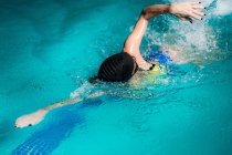 Atleta nadando en el agua de la piscina cubierta . - foto de stock