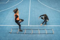 Молодая женщина упражнения с личным тренером фитнес с помощью гибкость лестница, ловкость навыки совершенствования . — стоковое фото