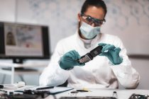 Female digital forensic science analyst examining confiscated mobile phone. — Stock Photo
