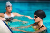 Mujeres nadadoras jóvenes nadando en la piscina de la piscina cubierta . - foto de stock