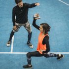 Молодая спортсменка поднимает гирь во время работы с личным тренером по фитнесу . — стоковое фото