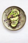Healthy vegan snack of fresh avocado on toasts with sprouts on round plate. — Stock Photo