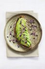 Gesunder veganer Snack aus frischer Avocado auf Toast mit Rosenkohl auf rundem Teller. — Stockfoto
