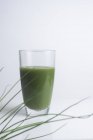 Green juice made of fresh wheatgrass on white background. — Stock Photo