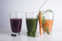 Fresh juices made of berries, carrot and green leaves. — Stock Photo