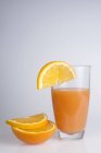 Sumo de laranja espremido na hora e fatias de laranja . — Fotografia de Stock