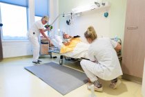 Hospital geriátrico. Enfermeras ayudando a un paciente confuso en la sala geriátrica de un hospital. - foto de stock