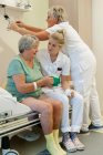 Geriatric hospital ward. Nurses helping a confused patient on the geriatric ward of a hospital. — Stock Photo