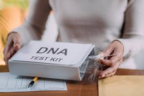 Старша жінка робить поштовий тест ДНК вдома . — стокове фото