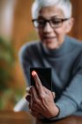 Взрослая женщина с помощью приложения для смартфонов, измерения пульса . — стоковое фото