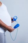 Mulher grávida escondendo um dispositivo de treinamento do assoalho pélvico para se preparar para o parto natural. — Fotografia de Stock
