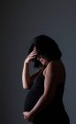Mujer embarazada y triste cubriendo la cara - foto de stock
