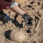 Archeologo che scava antichi resti umani in un sito archeologico. — Foto stock
