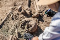 Escavações arqueológicas. Arqueólogo realizando pesquisas sobre ossos humanos antigos. — Fotografia de Stock