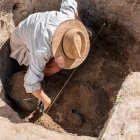 Archaeologist digging up ancient pottery at an archaeological site. — Stock Photo