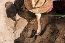 Arqueólogo escavando cerâmica antiga em um sítio arqueológico. — Fotografia de Stock