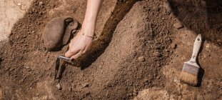 Археолог копает лопатой, восстанавливает керамику с археологических раскопок. — стоковое фото