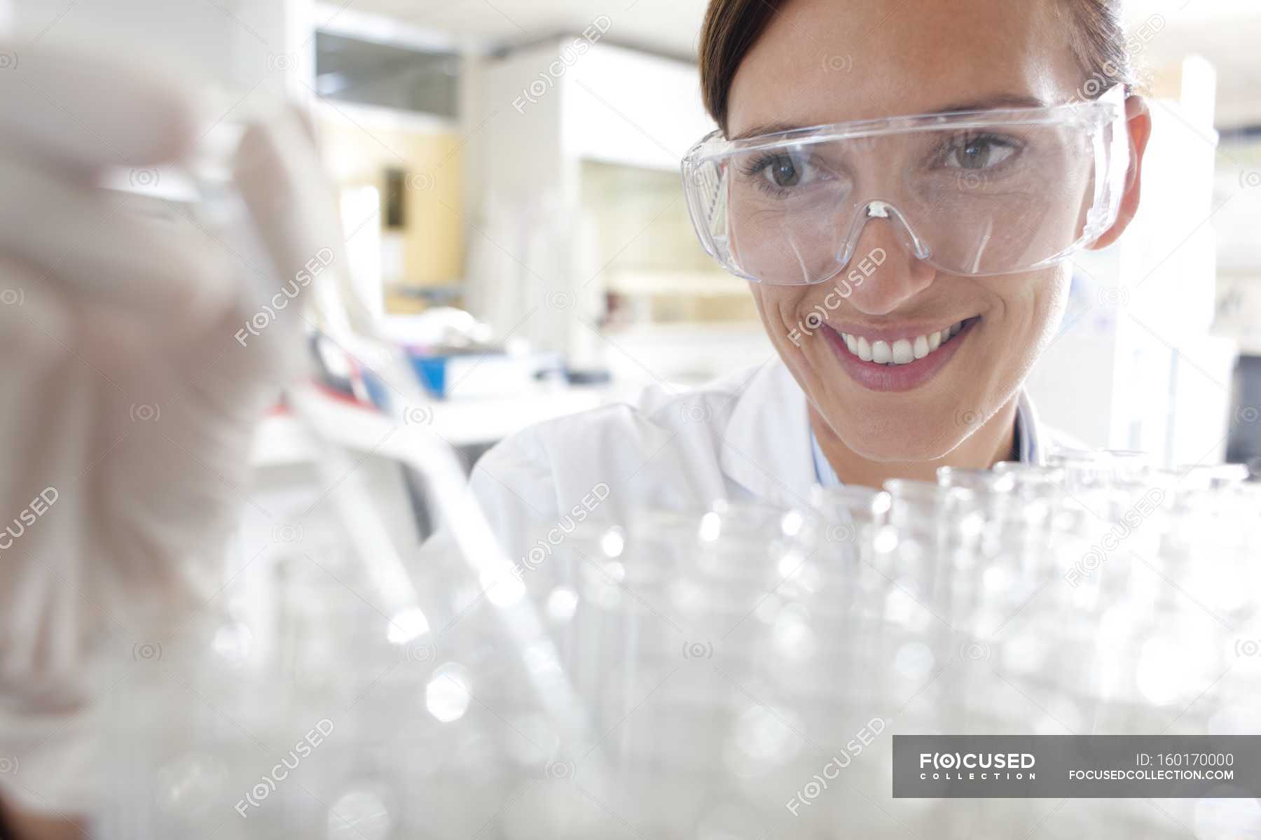 female-scientist-taking-testing-tube-from-tray-for-scientific-research