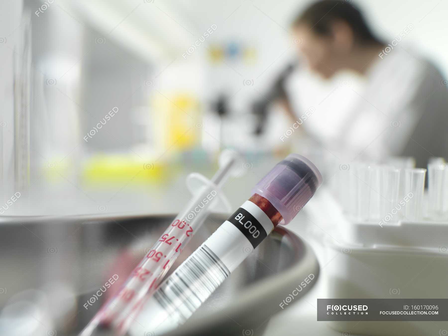 Close up of tube and syringe in hematology laboratory with scientist in